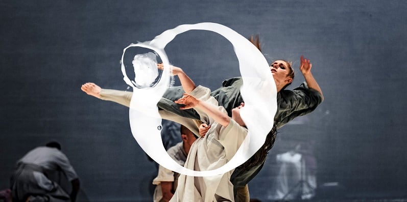 Två dansare bakom en vit cirkel. Foto: Happy F&B