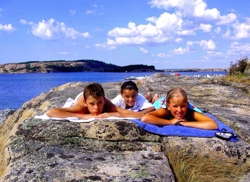 Tre barn ligger o solar på en klipphäll. Foto: SJ