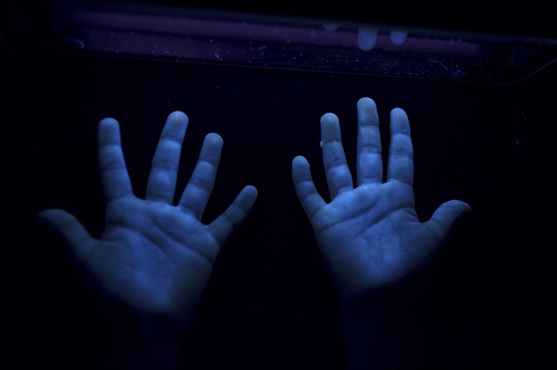 Blåtonad bild på två händer. Fotograf: Åsa Sjöström