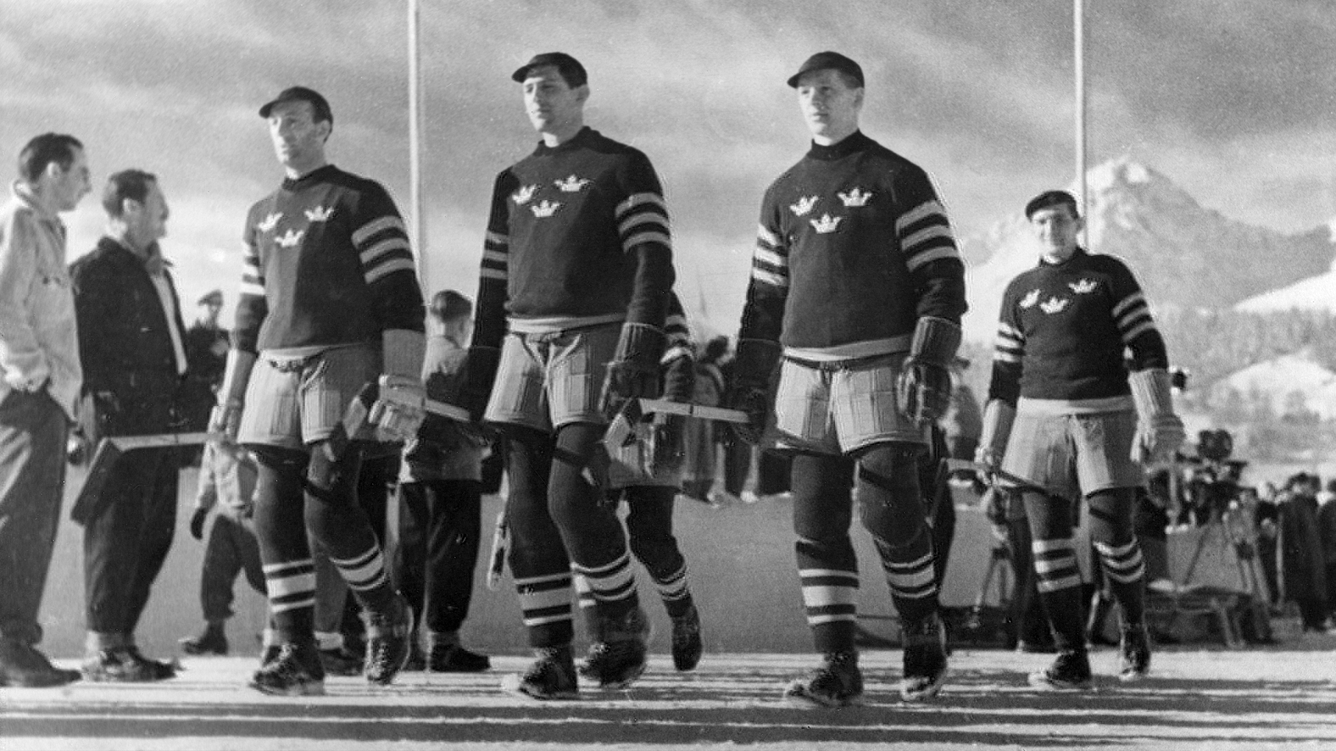 De svenska ishockeyspelarna tågar in på Isstadion i Sankt Moritz under öppningsceremonin vid de olympiska vinterspelen 1948 Foto: SVT 