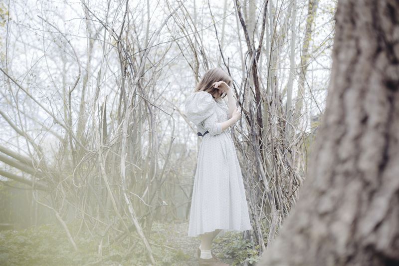Flicka i vit klänning i skog.  Foto: Jessica Silversaga